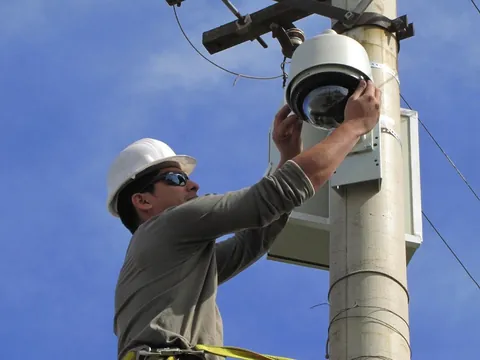 Técnico instalando una cámara domo PTZ en un poste